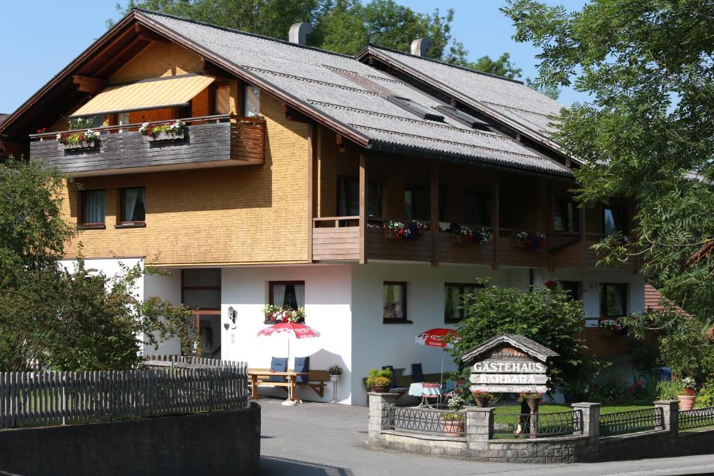 ein Haus mit einem Balkon und einem Schild davor in der Unterkunft Gästehaus-Pension Barbara in Andelsbuch