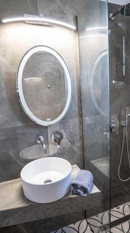 a bathroom with a white sink and a mirror at Mythic Villas in Epanomi