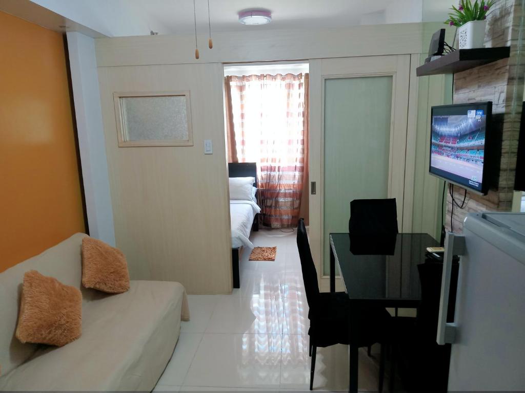 a living room with a couch and a table with a television at Vangie's Place at SEA RESIDENCES in Manila