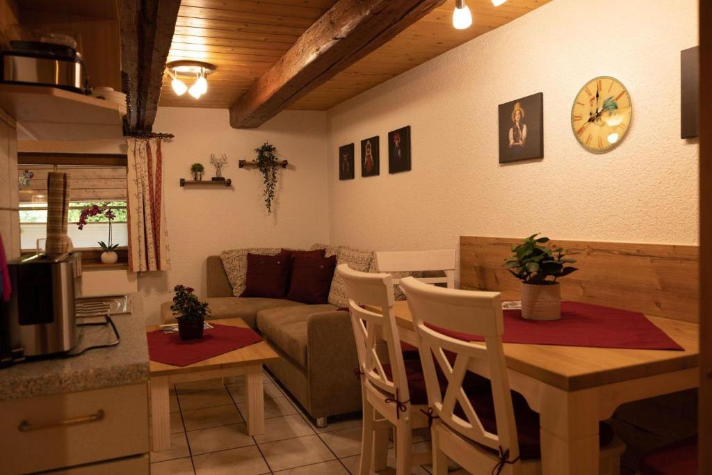 uma sala de estar com uma mesa e um sofá em Ferienhof-Gerda-Ferienwohnung-Storchennest em Oberkirnach