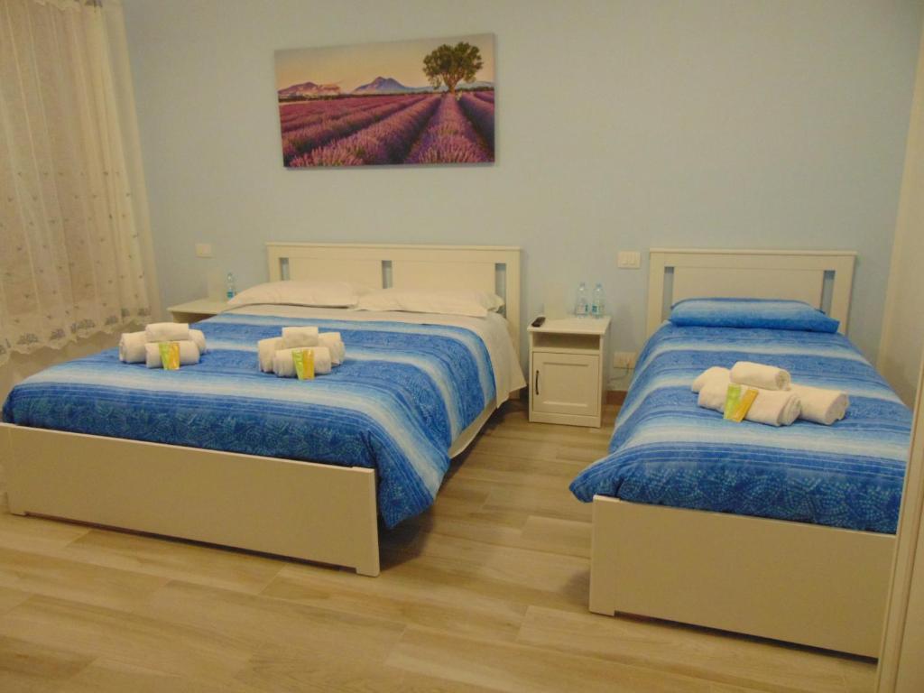 a bedroom with two beds and a painting on the wall at La stazione in Monselice