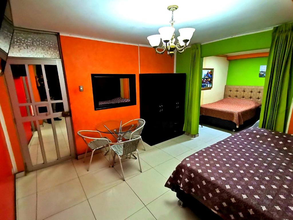 una camera da letto con pareti arancioni e verdi e un letto di Sombrero de Paja a Chiclayo