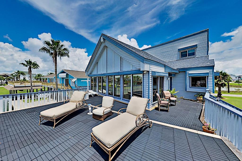 a house with a deck with chairs and a pool at Tiki Hideaway in Village of Tiki Island