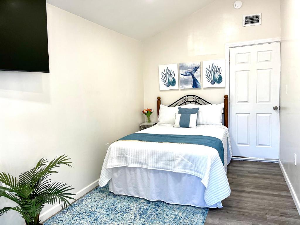 a white bedroom with a bed and a tv at Water Canal Villa Salgado in Bellmore
