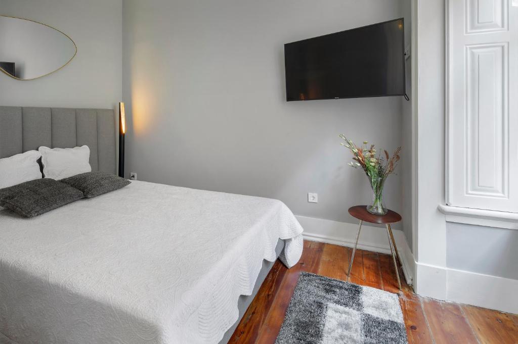 a bedroom with a bed and a television on the wall at Small Design Studio - Rosa, Bairro Alto in Lisbon