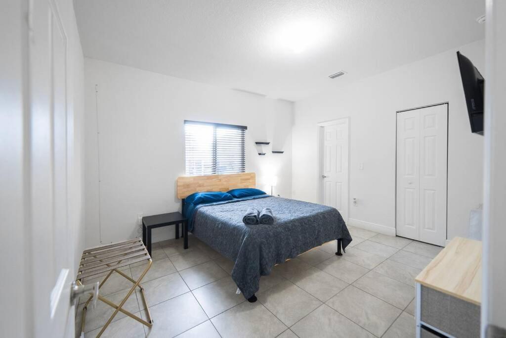 a bedroom with a bed with a blue blanket on it at New house on the block near Miami Airport. in Miami