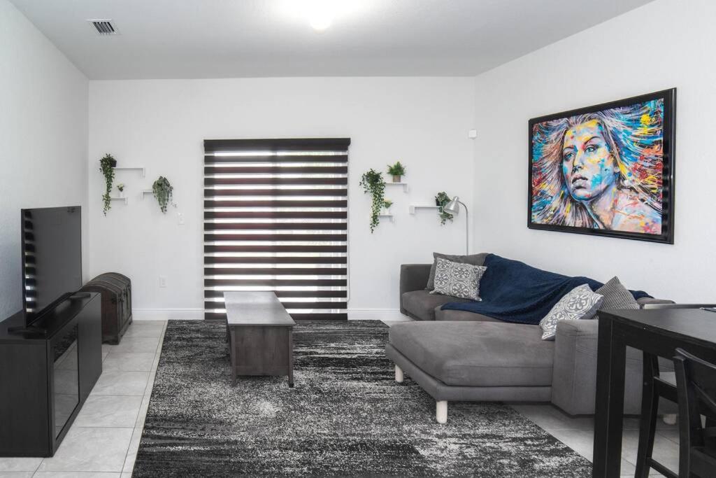 ein Wohnzimmer mit einem Sofa und einem Gemälde an der Wand in der Unterkunft New house on the block near Miami Airport. in Miami