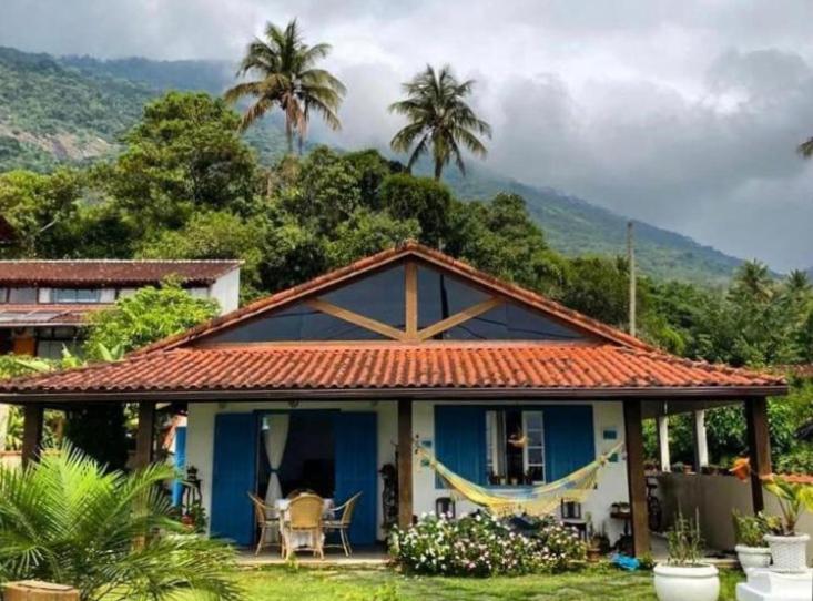 a blue and white house with a table and chairs at Aretê Ilha Grande in Abraão