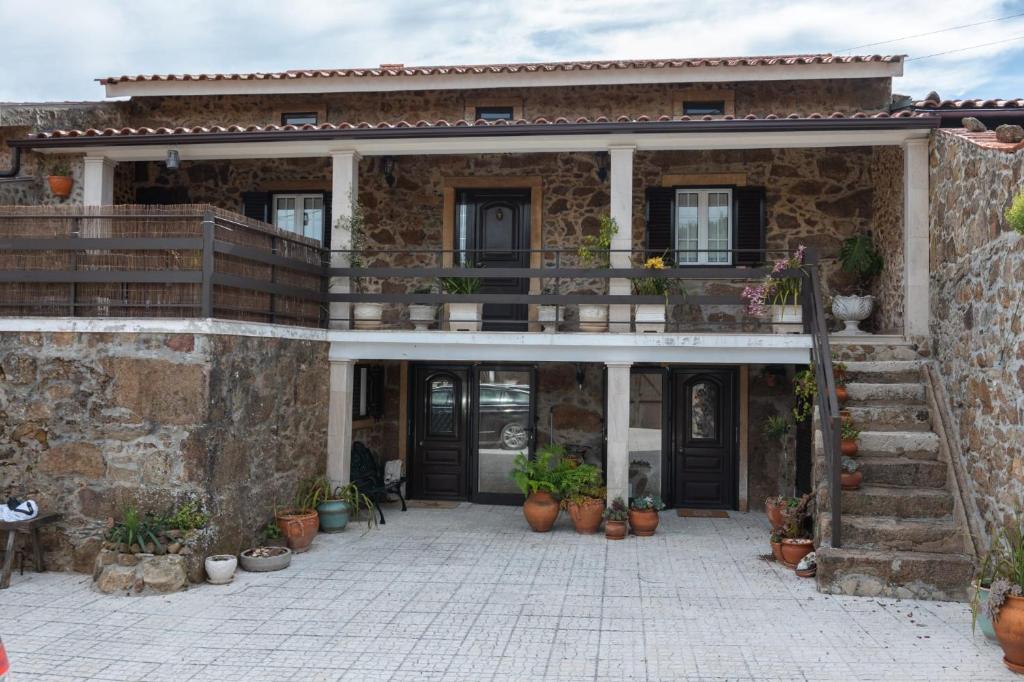 uma casa de pedra com vasos de plantas em frente em Casa do Canto em Coimbra