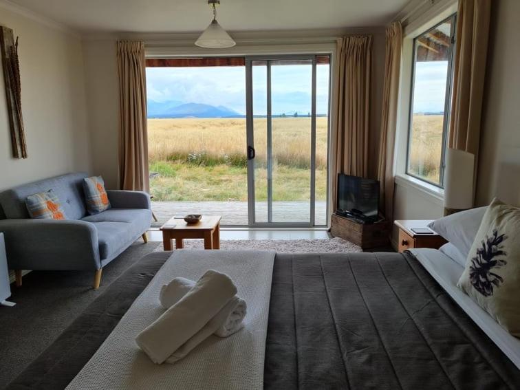 sypialnia z dużym łóżkiem i salonem w obiekcie The Lodge, with Mt Cook views w mieście Twizel