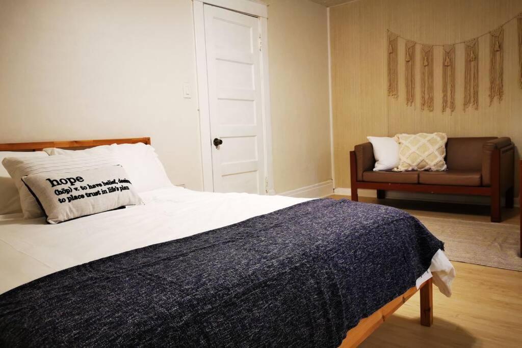 a bedroom with a bed with a couch and a chair at Zen style 3 bedrooms walking to the Falls USA in Niagara Falls