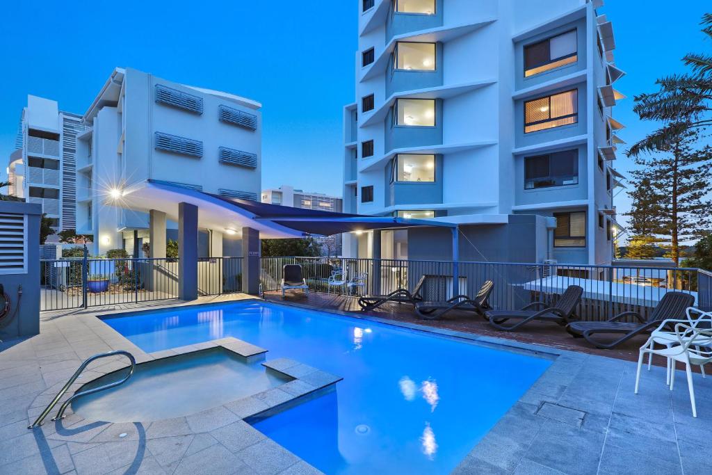 a swimming pool in front of a building at Cerulean Apartments in Caloundra