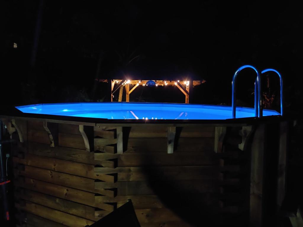 a blue swimming pool at night with lights at Escale Caraibes in Trois-Rivières