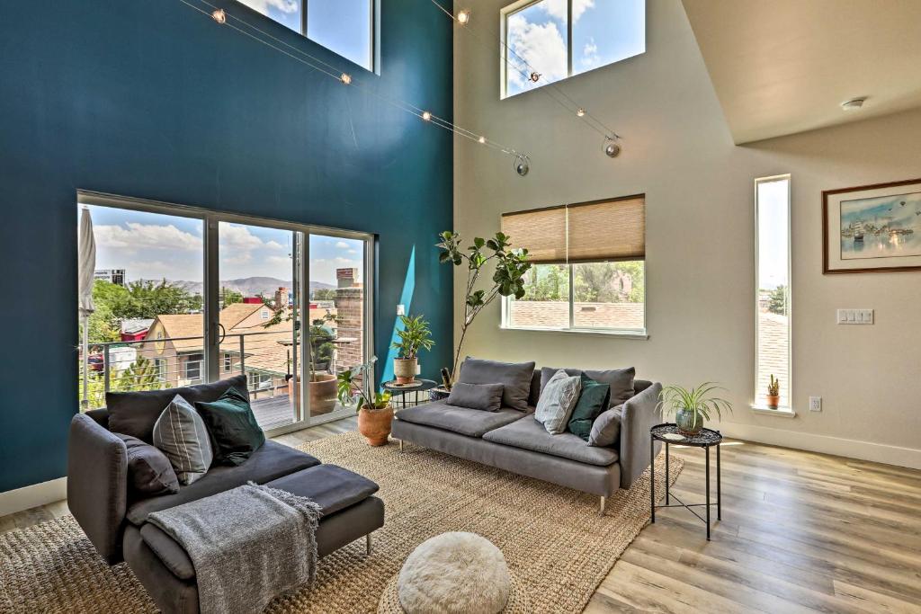 a living room with two couches and a blue wall at Reno Townhome with Mountain-View Rooftop Deck! in Reno
