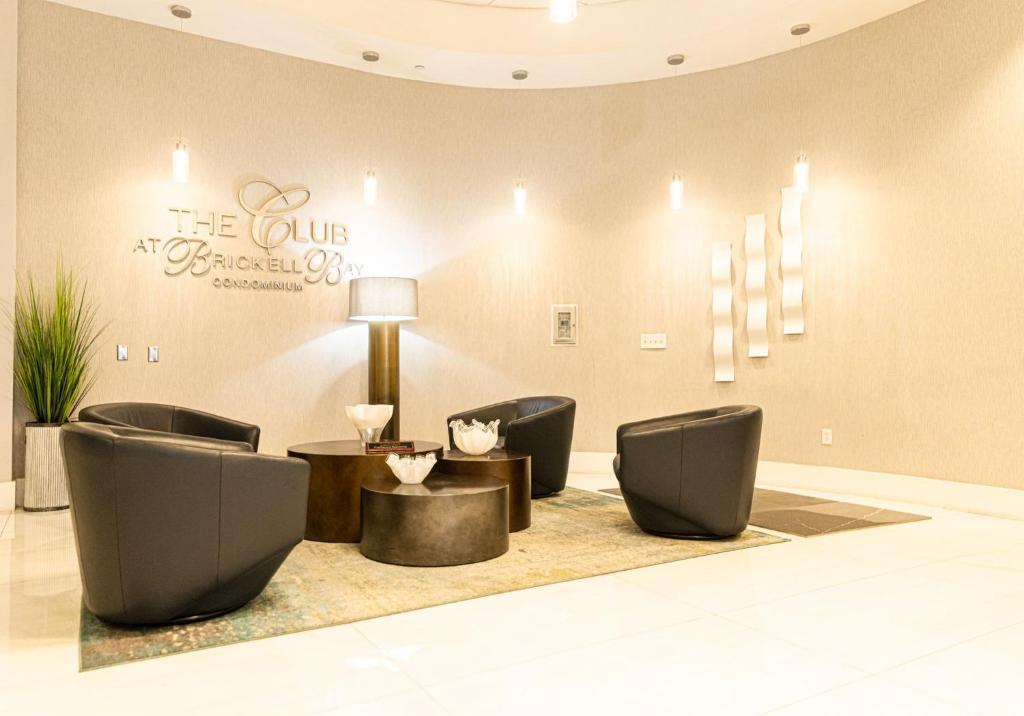 a lobby with chairs and a table and a sign at Brickell Apartments with Oceanview in Miami