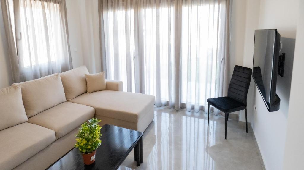 a living room with a white couch and a chair at Mythic Villas in Epanomi