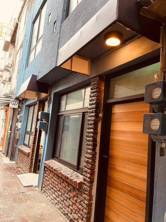 a building with a wooden door on a street at 三田包棟旅宿MITA Inn in Tainan