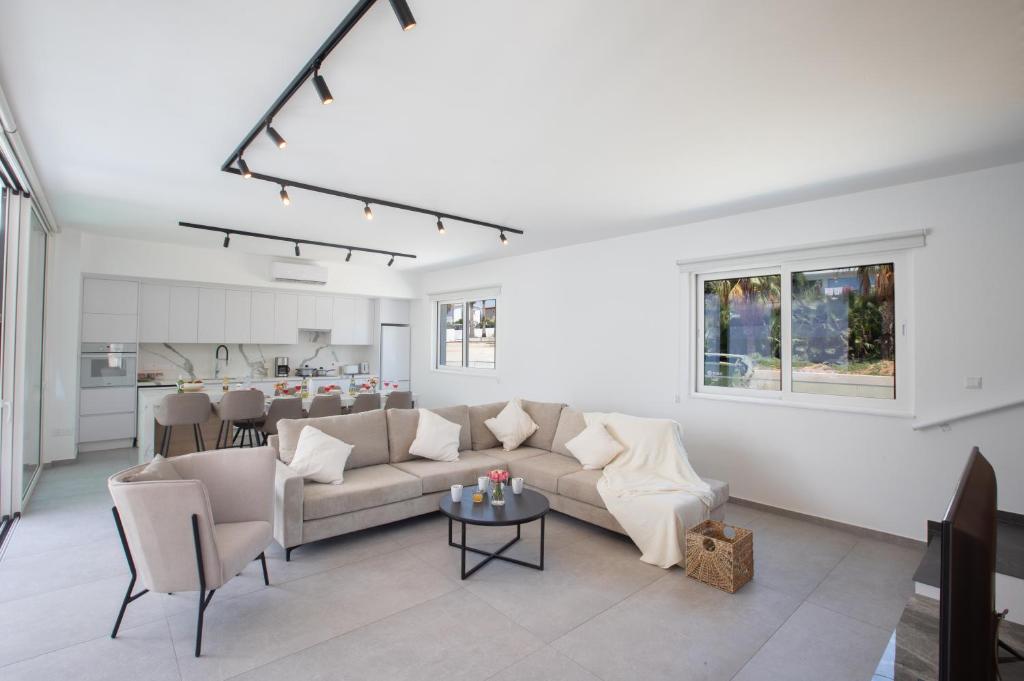 a living room with a couch and a table at Kube Luxury Villas in Ayia Napa