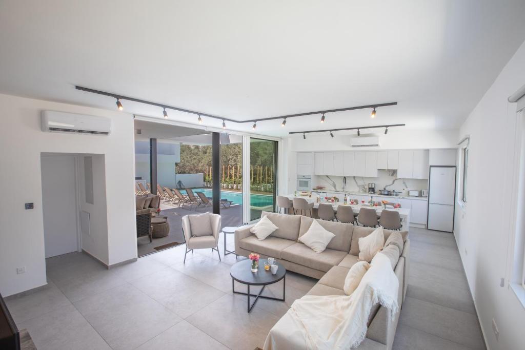 a living room with a couch and a kitchen at Kube Luxury Villas in Ayia Napa