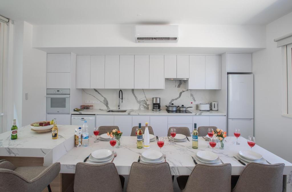 a large white kitchen with a table and chairs at Kube Luxury Villas in Ayia Napa