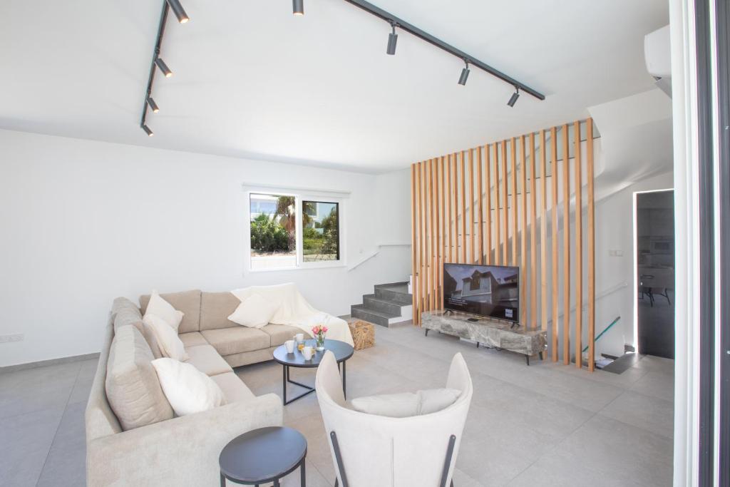 a living room with a couch and a fireplace at Kube Luxury Villas in Ayia Napa