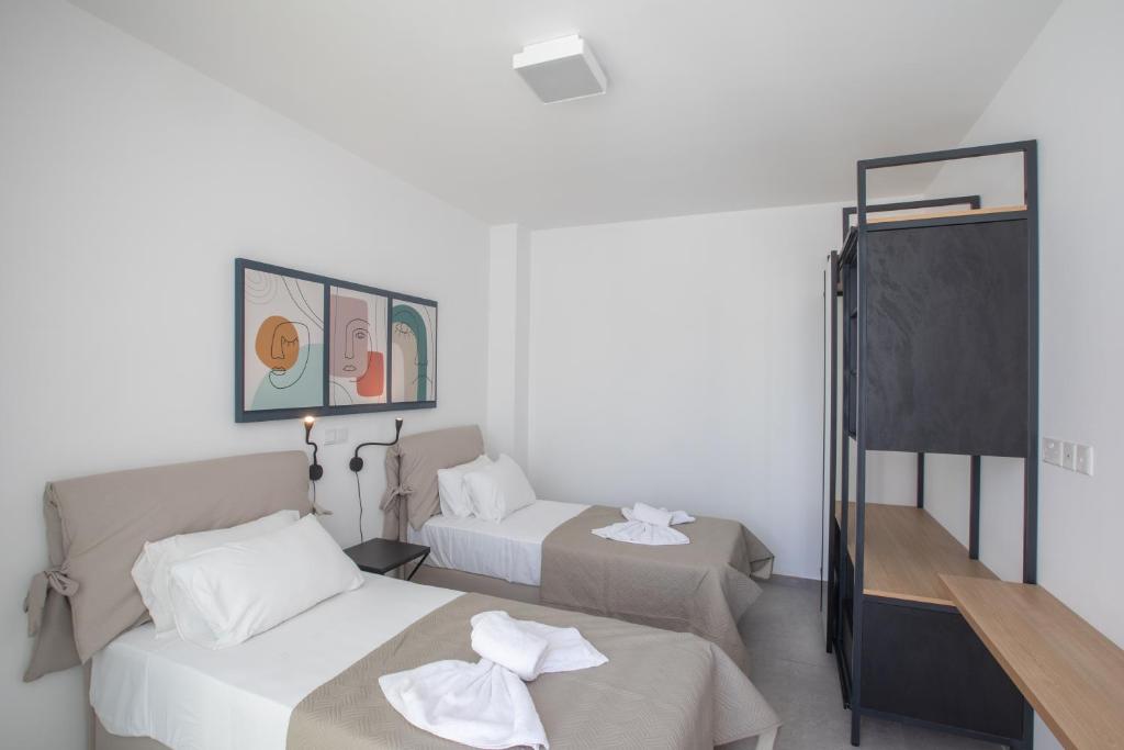 a hotel room with two beds and a mirror at Kube Luxury Villas in Ayia Napa