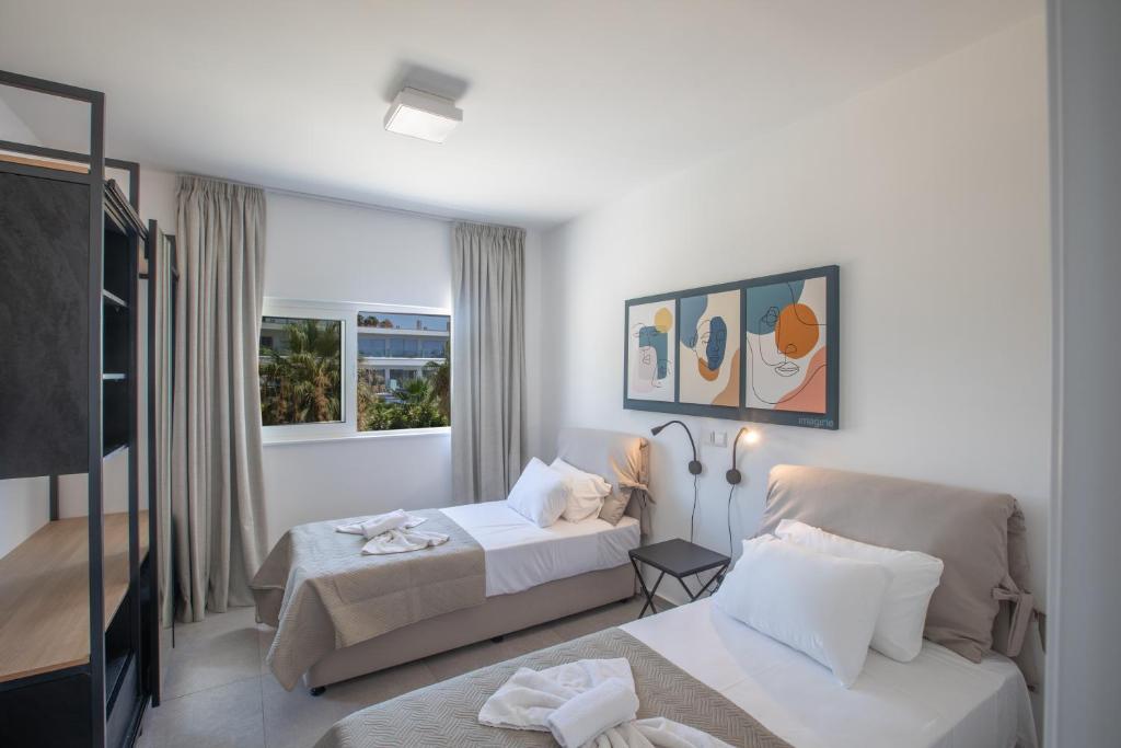 a hotel room with two beds and a television at Kube Luxury Villas in Ayia Napa