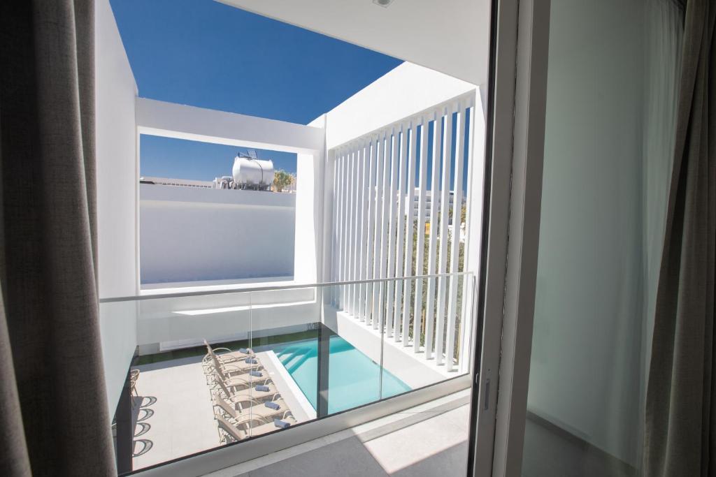 a room with a balcony with a view of the ocean at Kube Luxury Villas in Ayia Napa