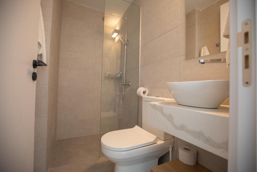 a bathroom with a toilet and a sink and a shower at Kube Luxury Villas in Ayia Napa