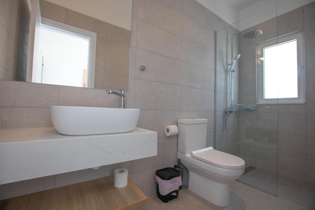a bathroom with a sink and a toilet and a shower at Kube Luxury Villas in Ayia Napa