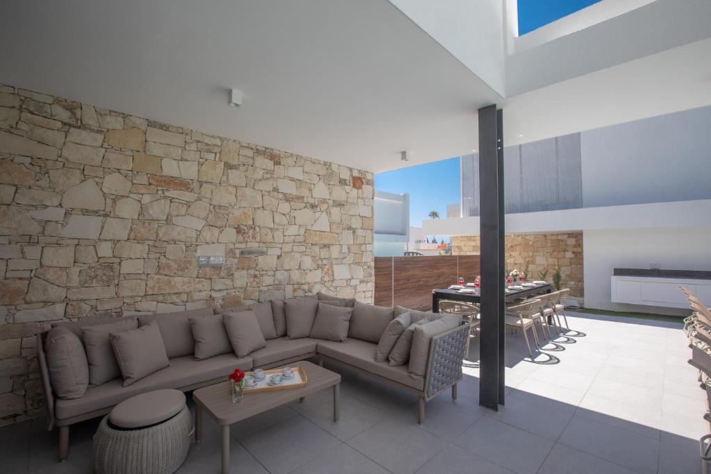 a living room with a couch and a stone wall at Kube Luxury Villas in Ayia Napa