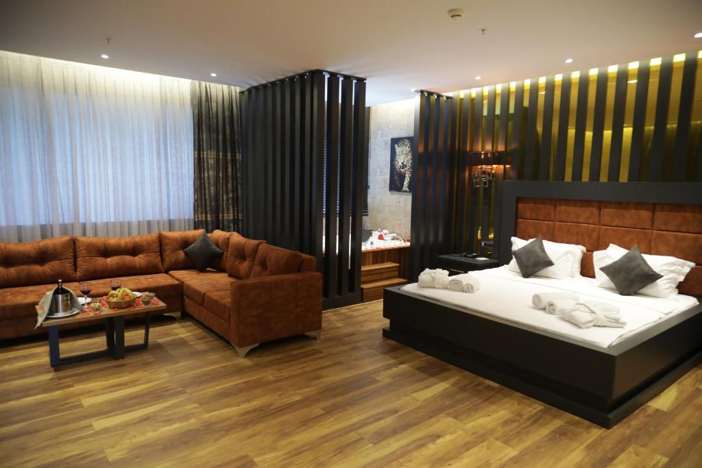 uma sala de estar com uma cama e um sofá em Sirin Park Hotel em Adana