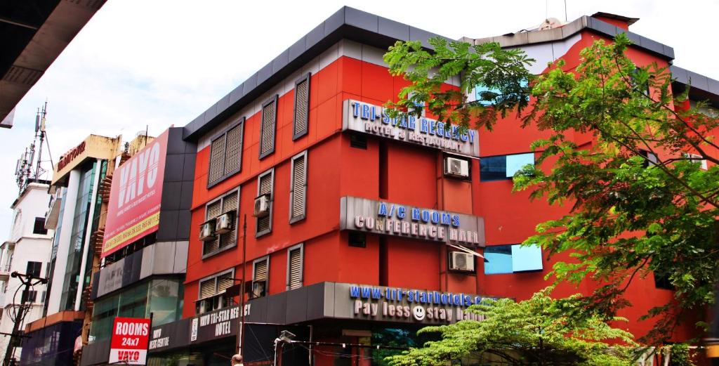 a red building with signs on the side of it at TRISTAR REGENCY HOTEL in Ernakulam