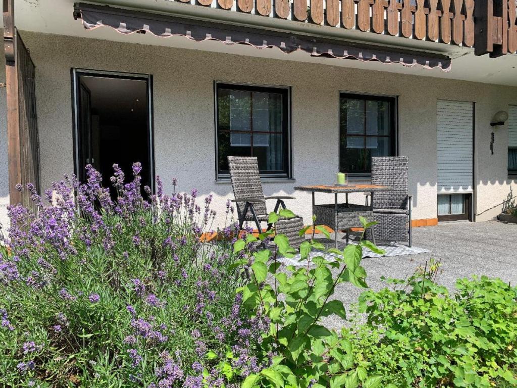 un patio con sillas y una mesa frente a una casa en Appartement Sonnenblick en Kollnburg