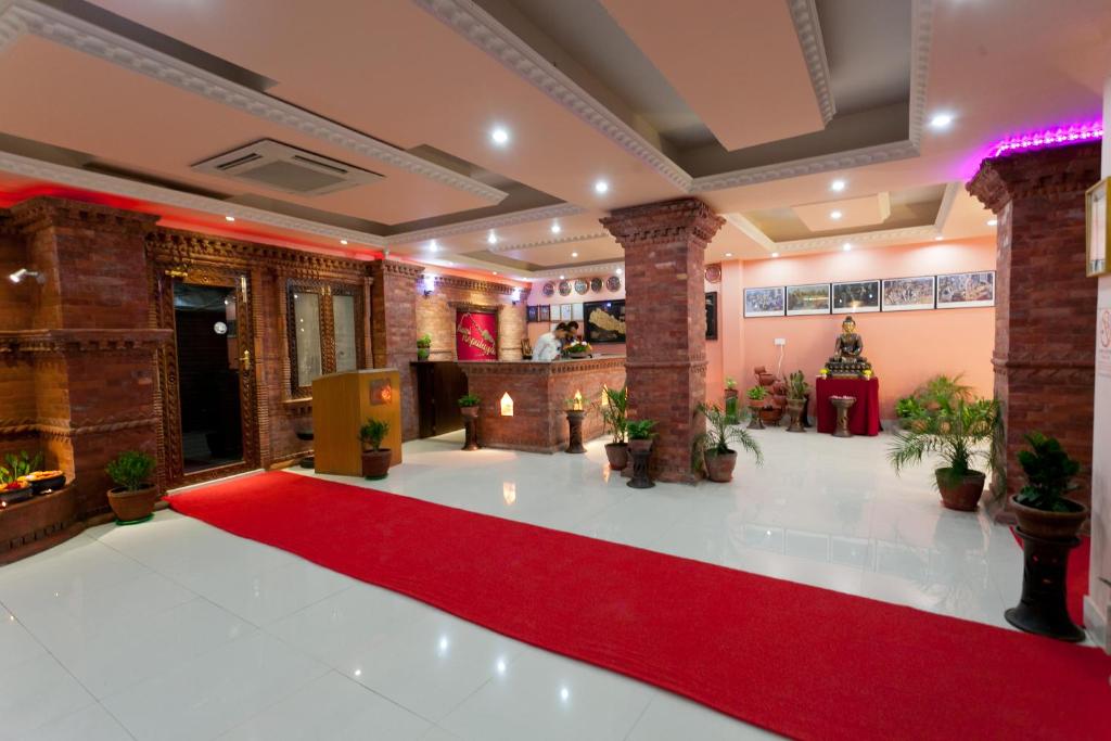 a large room with a red carpet and a large clock on the wall at Hotel Nepalaya in Kathmandu
