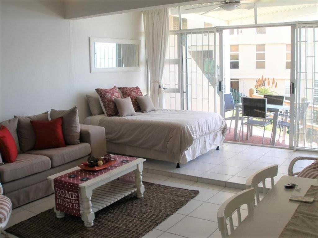 a living room with a bed and a couch at Camarque 28 in Umdloti