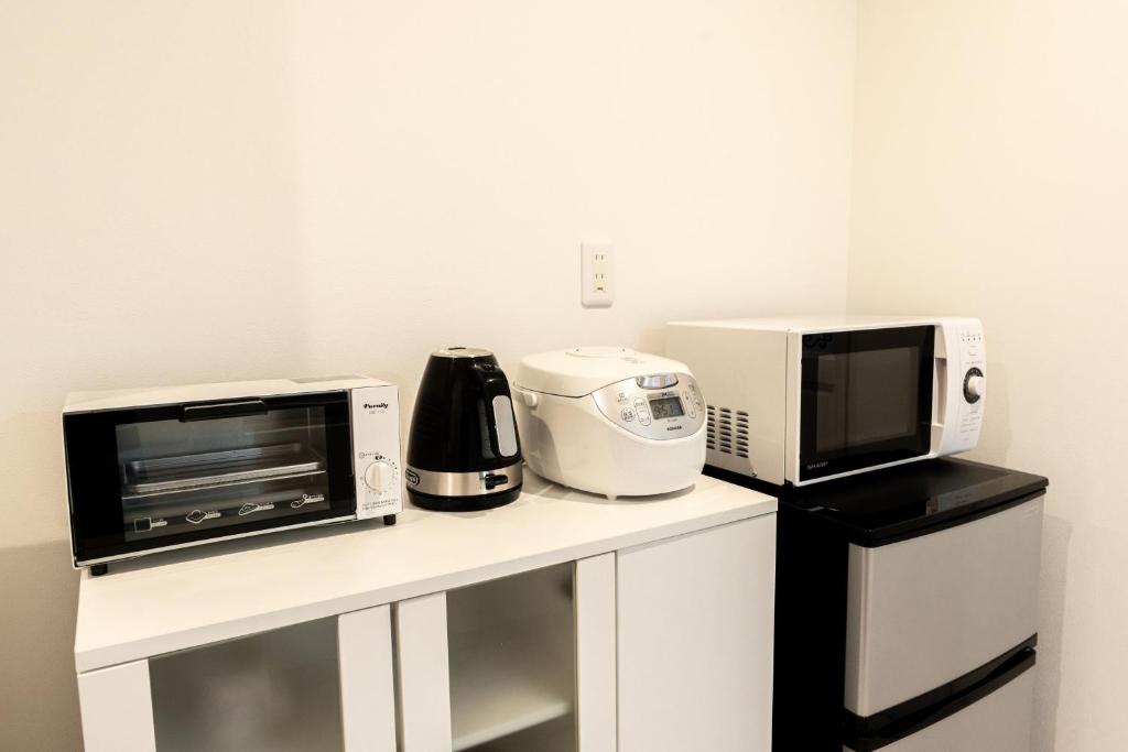 a kitchen with a microwave and a toaster oven at Hotel Santa Barbara Miyakojima Resort in Miyako-jima