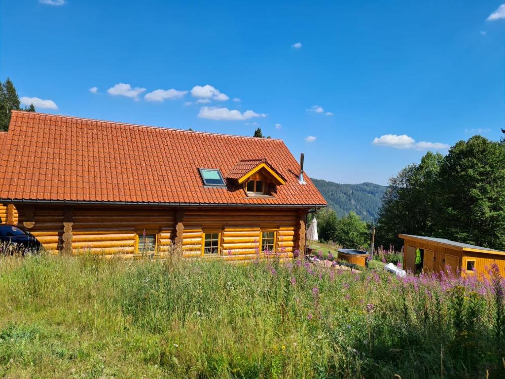 einem Blockhaus mit rotem Dach in der Unterkunft Luxus-Ferienhaus Blockhaus Chalet Nr 2 Toplage am Feldberg mit Sauna, Outdoor-Hottub, Kamin auf 1300m üM in Feldberg