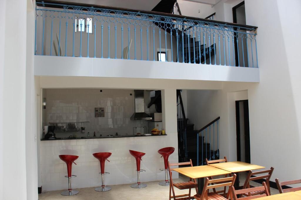 una sala da pranzo con tavolo e sgabelli rossi di Montevideo Chic Hostel a Montevideo