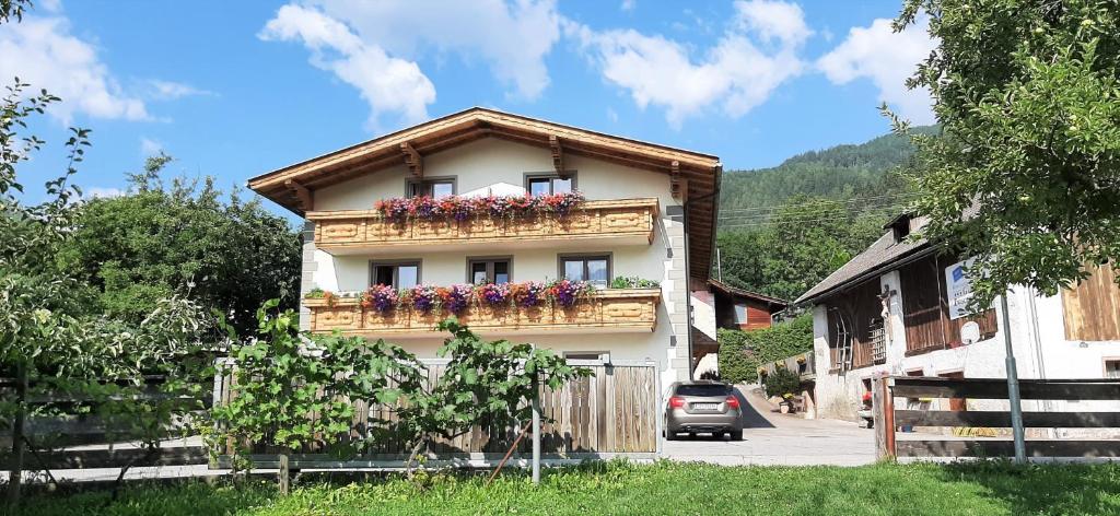a building with a balcony with flowers on it at Gästehaus Zwischenberger in Obervellach