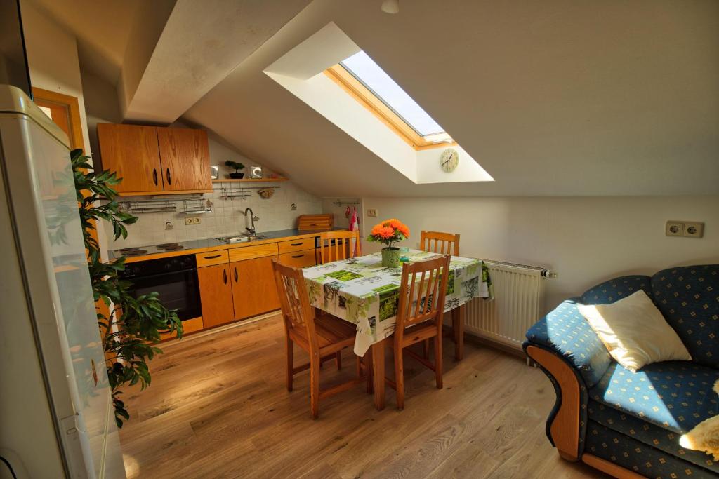 a kitchen and dining room with a table and a couch at Ferienwohnung-auf-dem-Bauernhof-fuer-4-oder-5-Personen-im-Herzen-Niederbayerns in Mamming