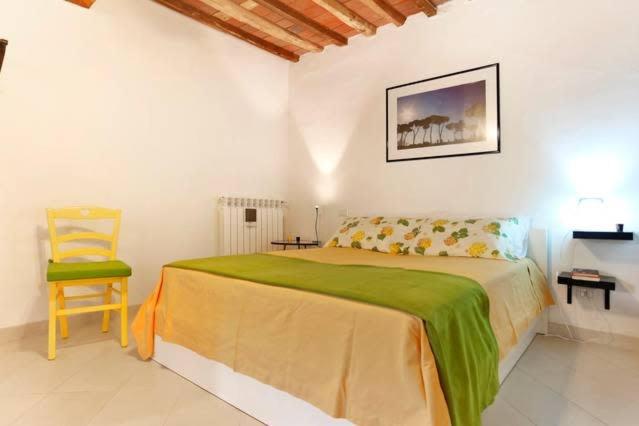een slaapkamer met een groot bed en een stoel bij Casa Amorino in Lucca