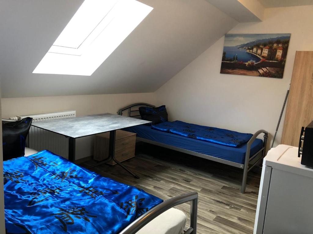 NittendorfにあるPension Monteurzimmer Fremdenzimmerのベッドとテーブルと窓のある部屋