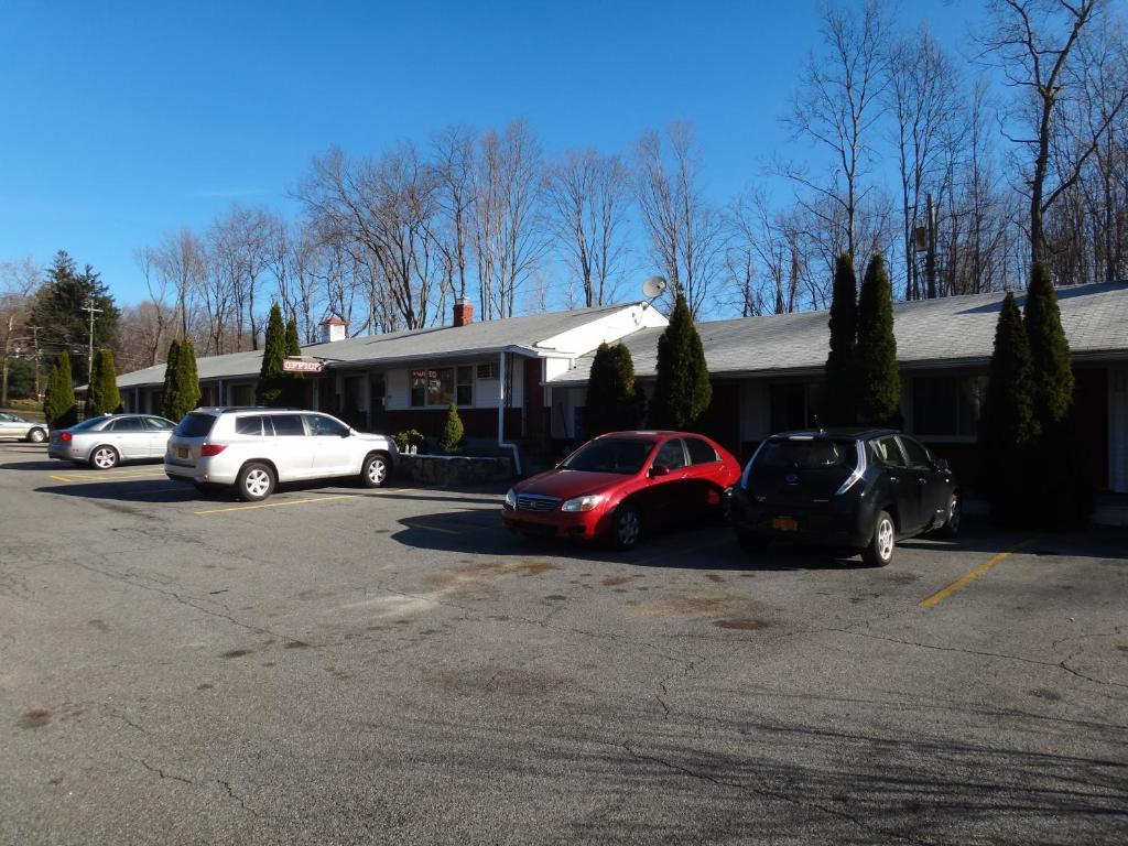 a group of cars parked in a parking lot at Budget Motor Inn- Mahopac in Mahopac
