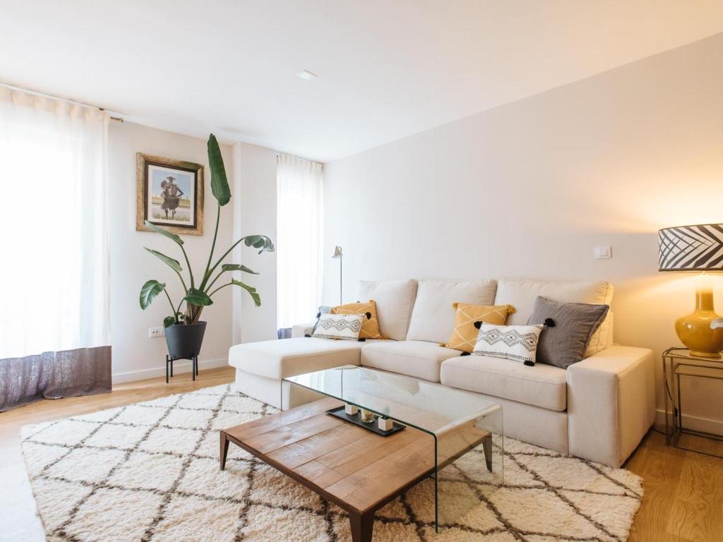 a living room with a white couch and a coffee table at Pz triana amplio, moderno y luminoso apt 2d 2b in Seville