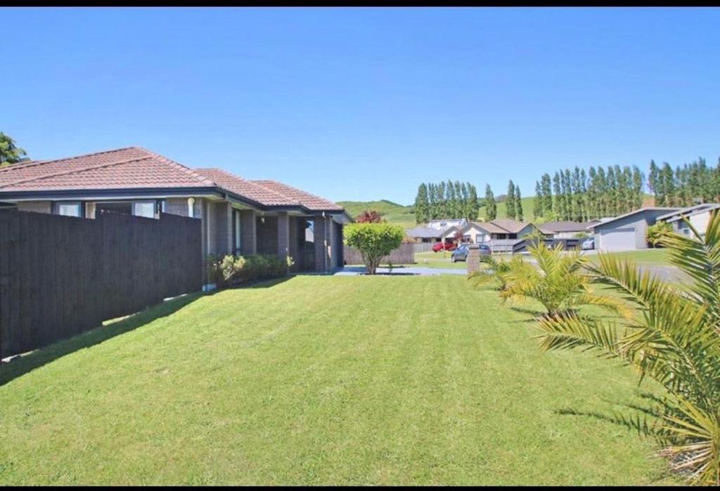 un gran patio con una valla y una casa en Your Happy place-Quiet area & Spa pool, en Rotorua