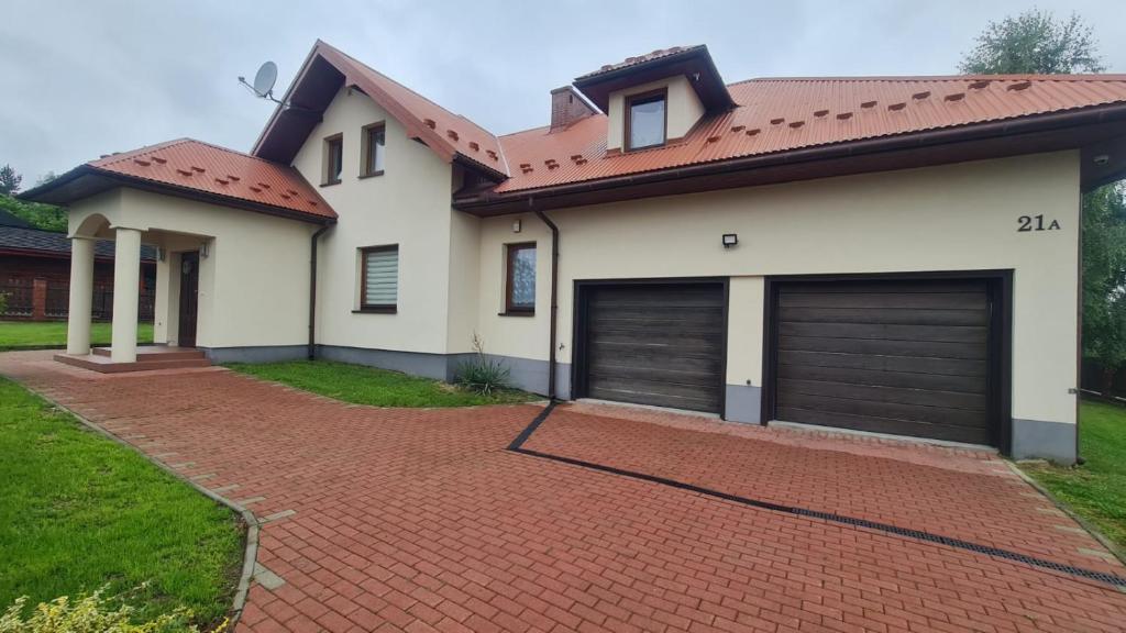 una casa con due porte garage su un vialetto di mattoni di Cztery Pory Roku a Rabka-Zdrój