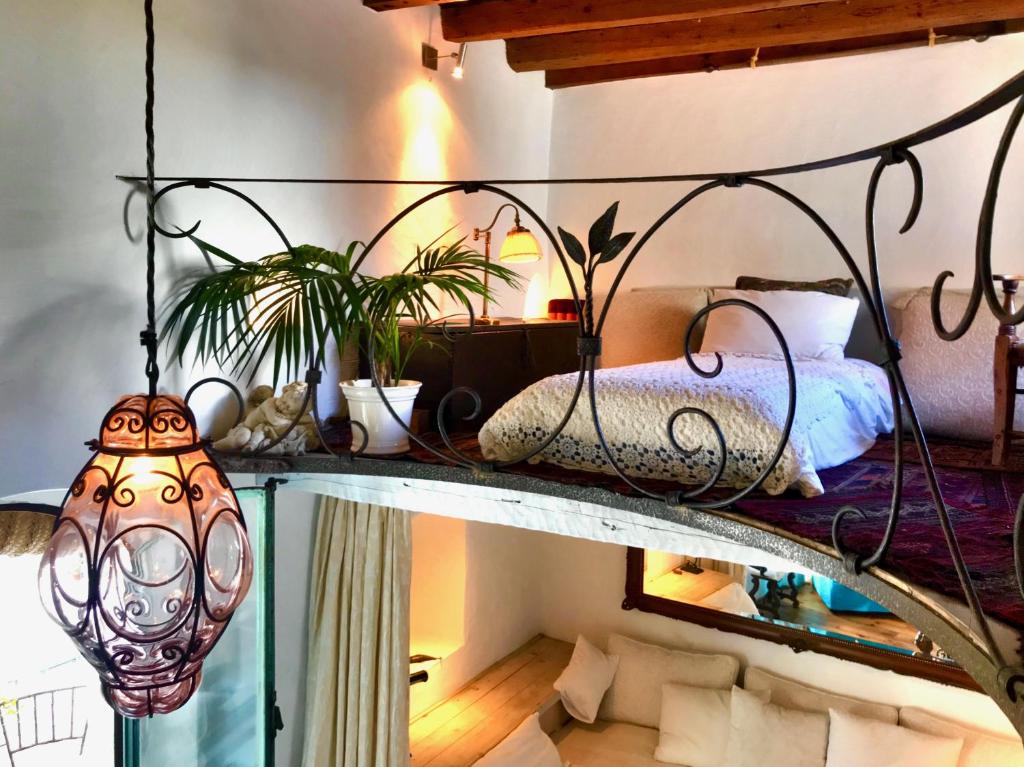 łóżko na podwyższeniu z lustrem i żyrandolem w obiekcie JUDERIA LUXURY SUITE Casas Vejer Debra w mieście Vejer de la Frontera