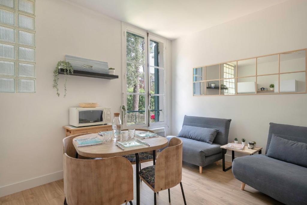 un salon avec une table et un canapé dans l'établissement 130m de la plage ! Séjour à 4, à La Baule