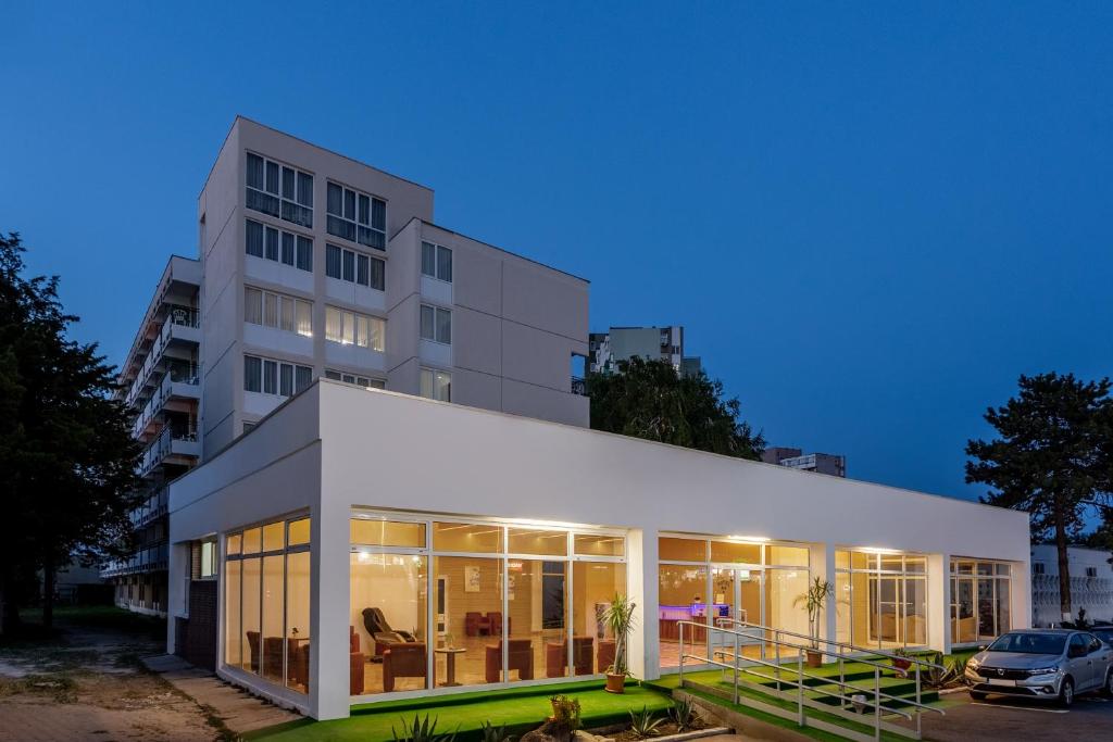 a large white building with a car parked in front of it at Hotel Siret Saturn in Saturn